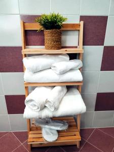 a wooden shelf with towels and a potted plant at Deluxe Alba in Locorotondo