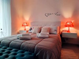 a bedroom with a large bed with two lamps at Deluxe Alba in Locorotondo