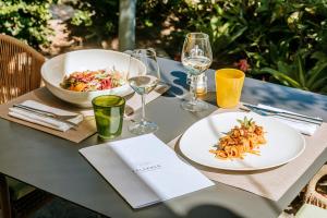 a table with a plate of food and glasses of wine at Hotel Parco Smeraldo Terme in Ischia