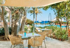 a patio with tables and chairs and a pool at Hotel Parco Smeraldo Terme in Ischia