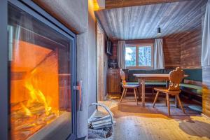 a living room with a fireplace and a table and chairs at Nüggili's Maisäß in Tschagguns