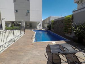 邦比尼亞斯的住宿－Edíficio Varadero，一座带椅子的庭院和一座位于大楼内的游泳池