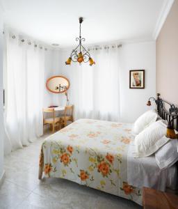 1 dormitorio con cama, mesa y lámpara de araña en Hostal Barrera, en Madrid