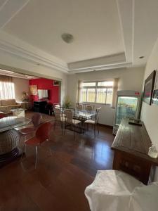 ein Wohnzimmer mit Tischen und Stühlen sowie ein Esszimmer in der Unterkunft Pousada Vale do Rubi in Londrina