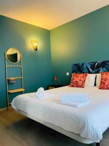 - une chambre avec un grand lit et un mur vert dans l'établissement Appartement proche centre historique avec parking, à Sarlat-la-Canéda