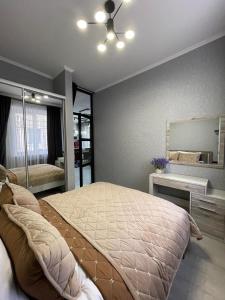 ein Schlafzimmer mit einem großen Bett und einem Spiegel in der Unterkunft VEL ЛЮКС in Czernowitz