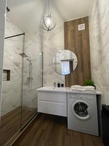a washing machine in a bathroom with a shower at VEL ЛЮКС in Chernivtsi +39 photos