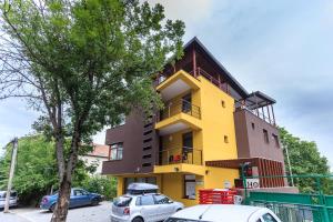 クルジュ・ナポカにあるAparthotel Gutinuluiの車が目の前に停まった黄色い建物