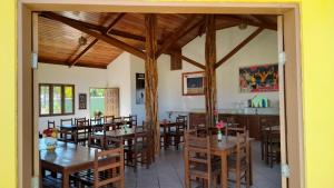a dining room with wooden tables and chairs at Pousada Costa do Sol in Canavieiras