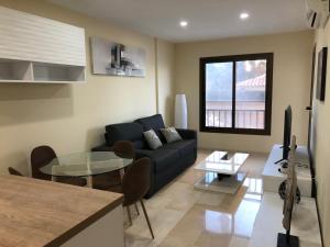 - un salon avec un canapé et une table en verre dans l'établissement Moderno Apartamento en Primera línea Paseo Marítimo Fuengirola, à Fuengirola
