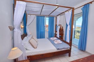 a bedroom with a canopy bed with a balcony at Effi's Garden Villa in Limenas +25 photos