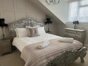 a bedroom with a large white bed and a staircase at Goshen Cottage in Kelso