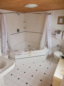 a white bathroom with a tub and a toilet at Adair Country Inn & Restaurant in Bethlehem