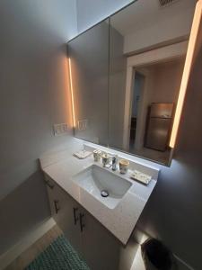 a bathroom with a sink and a large mirror at Cozy Guest Suite in Quiet Home with Private Entry in Vancouver