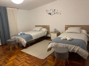 1 dormitorio con 2 camas y 2 taburetes en Casa Ribe, en Tui