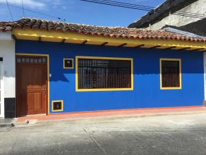 uma casa azul com uma porta castanha numa rua em La Rosa Buga em Guadalajara de Buga