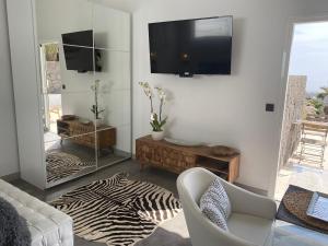 A television and/or entertainment centre at Luxury studio, sea view, pool