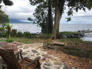 a couple of chairs sitting next to the water at Hostal Así es mi Tierra in Balgue