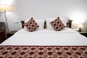 a bedroom with a large white bed with two pillows at SHANU'S SEASIDE INN - A Guesthouse, 100 metres to Candolim Beach in Candolim