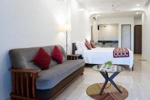 ein Wohnzimmer mit einem Sofa und einem Bett in der Unterkunft SHANU'S SEASIDE INN - A Guesthouse, 100 metres to Candolim Beach in Candolim