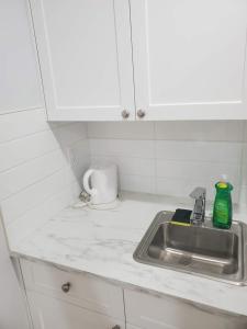 a kitchen counter with a sink and white cabinets at Cozy Guest Suite in Quiet Home with Private Entry in Vancouver