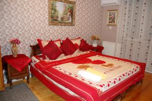 1 dormitorio con 1 cama grande con almohadas rojas en Excellent Hostel Kutaisi, en Kutaisi