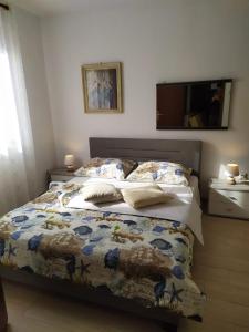 a bedroom with a bed with a comforter and a television at Apartments Spada in Poreč