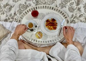 Ein Mann, der mit einem Teller Essen im Bett liegt. in der Unterkunft Casa Tua Vaticano Guest House in Rom