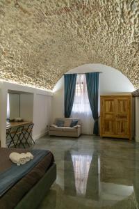 Zimmer mit einem Bett und einem Sofa sowie einer mit Steinen bedeckten Decke in der Unterkunft La Rondine in Tagliacozzo