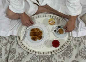 un hombre en la cama con un plato de comida y una taza de café en Casa Mia Vaticano Guest House, en Roma