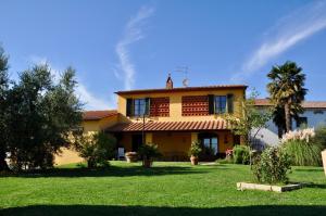 a large yellow house with a green yard at Agriturismo Tori 2 in Montecarlo