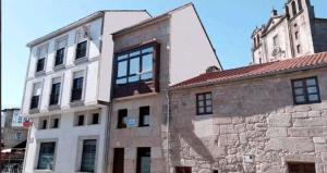 un antiguo edificio con una torre de reloj encima en Albergue con encanto d'camiño, en Padrón