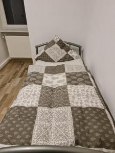 a bed with a quilt on it in a room at GSS18 1-OG Möblierte Wohnung in Oebisfelde in Oebisfelde