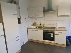 a kitchen with white cabinets and a stove top oven at GSS18 1-OG Möblierte Wohnung in Oebisfelde in Oebisfelde