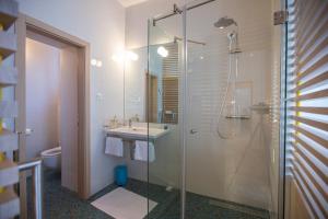 a bathroom with a glass shower and a sink at Bed & Atmosphere Rooms in Split