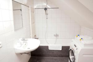 a white bathroom with a sink and a tub at gemütliche Wohnung in Hohenems in Hohenems