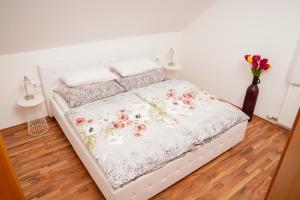 a bed in a bedroom with a floral bedspread at gemütliche Wohnung in Hohenems in Hohenems