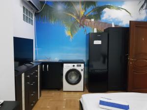 a room with a washing machine and a palm tree on the wall at Monza National Arena Mega Mall Ap in Bucharest