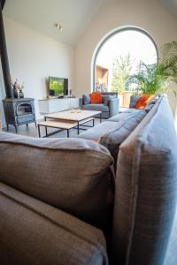 ein Wohnzimmer mit einem Sofa und einem Tisch in der Unterkunft Vakantiewoning De Machuut in Lo-Reninge