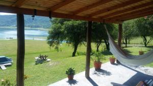 a porch with hammocks and a view of a lake at TIKI HUASI in Coronel Moldes