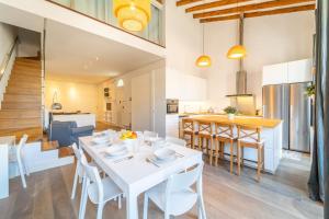 comedor y cocina con mesa blanca y sillas en LovelyLofts Altamira Duplex, en Alicante