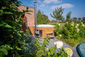 a hot tub in the middle of a garden at Vakantiewoning De Machuut in Lo-Reninge
