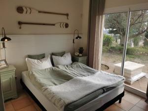 1 cama en un dormitorio con ventana en Villa Fourmaux en Néffiès
