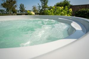 a hot tub filled with water in a backyard at Vakantiewoning De Machuut in Lo-Reninge