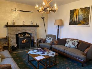 a living room with two couches and a fireplace at Garden Park Guest House in Grantown on Spey