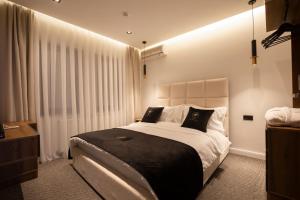 a bedroom with a large bed with black and white pillows at Plaza Boutique Hotel in Pristina