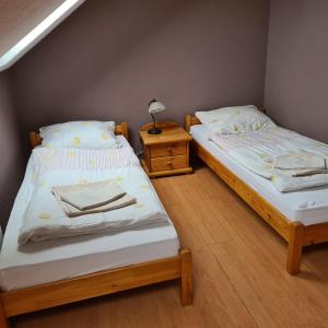 two twin beds in a room with a night stand at Restauracja Joanna in Gogolin