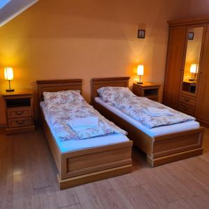 2 camas en una habitación con 2 lámparas en ambos lados en Restauracja Joanna, en Gogolin