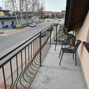 Un balcón con 2 sillas y una calle. en Restauracja Joanna, en Gogolin