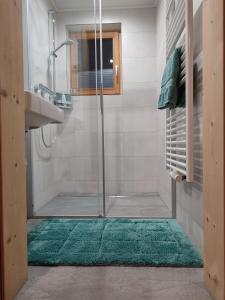 baño con ducha y alfombra verde en Walcheggerhof, en Innervillgraten
